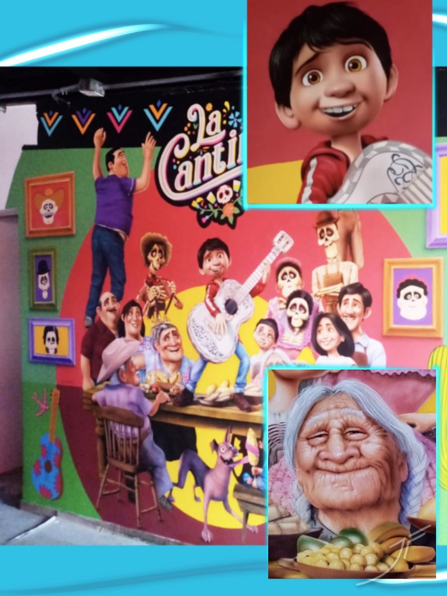 Mural colorido de una familia mexicana celebrando alrededor de una mesa, con un joven guitarrista y calaveras